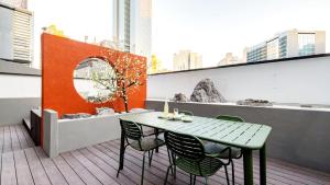 a green table and chairs on a balcony at Anook Resort & Spa Busan Haeundae in Busan