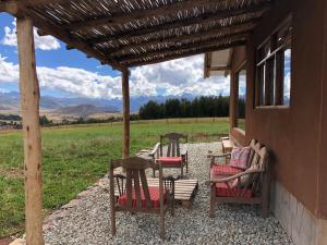 three chairs and a table on a porch with a view at Sami Huaypo Cabin in Cheqquerec