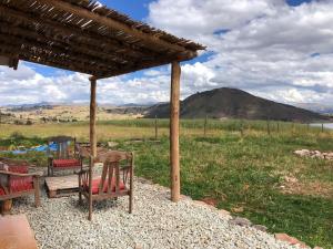 a table and chairs under a pavilion with a view of a mountain at Sami Huaypo Cabin in Cheqquerec