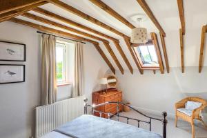 a bedroom with a bed and a chair and a window at 2 Bed in Field Dalling oc-1643 in Saxlingham