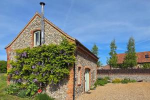 a brick building with flowers on the side of it at 2 Bed in Field Dalling oc-1643 in Saxlingham