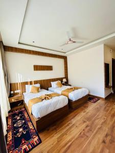 two beds in a room with wooden floors at Dema Rresort in Paro