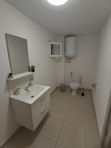 a white bathroom with a sink and a toilet at Rio rooms in Băile Herculane