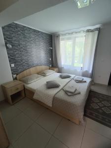 a bedroom with a large bed and a brick wall at Rio rooms in Băile Herculane