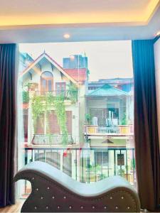 a window with a couch in front of a building at Bach Khoa Hotel in Hanoi