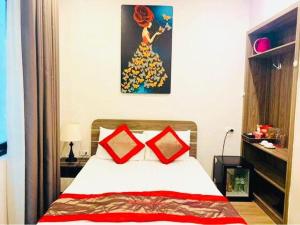 a bedroom with a bed with two red pillows at Bach Khoa Hotel in Hanoi