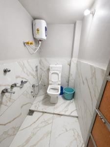 a bathroom with a toilet and a sink at Hotel Vasundhara in Garot