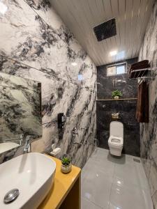 a bathroom with a sink and a toilet at Hotel Vasundhara in Garot