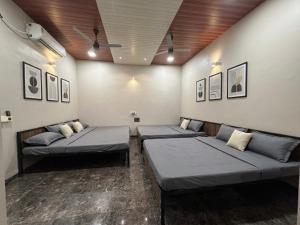 a room with three beds in a room at Hotel Vasundhara in Garot