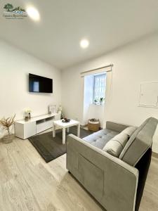 a living room with a couch and a tv at Figueira River House in Bragança