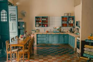 a kitchen with blue cabinets and a table and chairs at Hostal Vacaciones Nicas in León