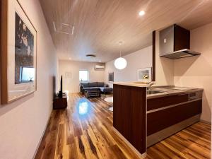 a kitchen with a counter and a living room at 内町3階 高松中心地 広いメゾネット貸切 2ベッドルーム 最大4名 in Takamatsu +18 photos