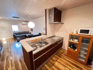 a kitchen with a sink and a living room at 内町3階 高松中心地 広いメゾネット貸切 2ベッドルーム 最大4名 in Takamatsu