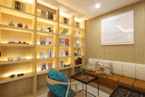 a living room with a couch and bookshelves at Nestly Hotel in Busan