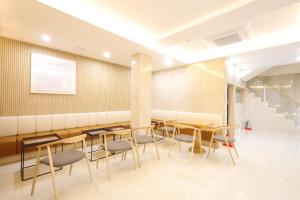 a room with tables and chairs and a staircase at Nestly Hotel in Busan