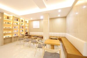 a dining room with tables and chairs and shelves at Nestly Hotel in Busan
