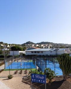a resort with several tennis courts in front of a building at La Manga Amarilla in Cartagena
