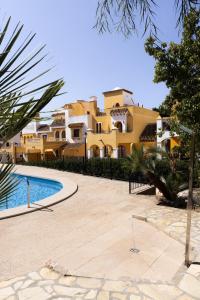 a large yellow building with a pool in front of it at La Manga Amarilla in Cartagena