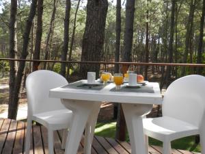 una mesa blanca y sillas en una terraza con árboles en Rincon de las Pampas, en Mar de las Pampas