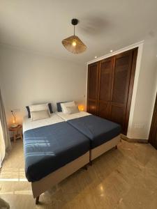 a bedroom with a large bed with a blue blanket at La Manga Amarilla in Cartagena +16 photos
