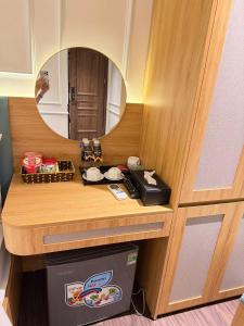 a mirror on a wooden counter with a drawer at Giang Son Hanoi Hotel in Hanoi