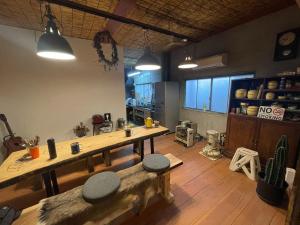 a kitchen with a table and two stools in a room at Old Sunny Garage in Tosashimizu