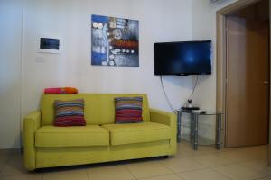 シルヴィ・マリーナにあるAppartamento al mareのリビングルーム(黄色のソファ、テレビ付)