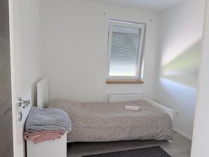 a small bedroom with a bed and a window at Apartment Doris in Tomislavgrad