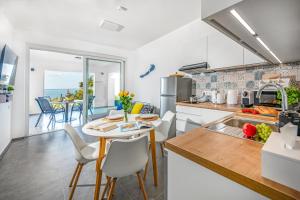 a kitchen with a table and chairs with a view of the ocean at Apartman 360 in Balatonalmádi