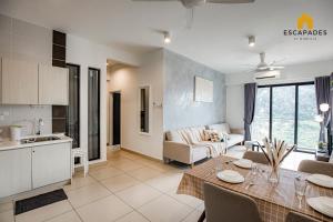 a kitchen and a living room with a table in a room at The Tropic@Midhill Genting (Free Wi-Fi) in Genting Highlands