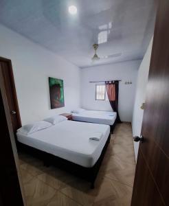 a bedroom with two beds in a room with a window at Apt vacacional 301 in Doradal