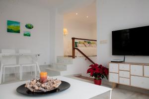 a living room with a table and a tv at El Jardín de Wallada in Córdoba