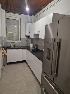 a kitchen with white cabinets and a stainless steel refrigerator at Appartement 45m2 à Florange in Florange