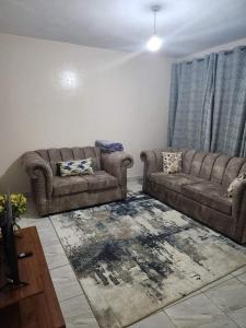 a living room with a couch and a rug at Muthiga Springs in Kikuyu