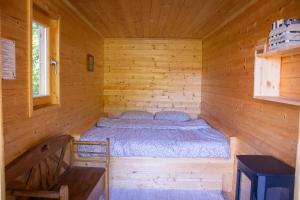 a room with a bed in a wooden cabin at Glamping Zeleni raj Vače in Vače