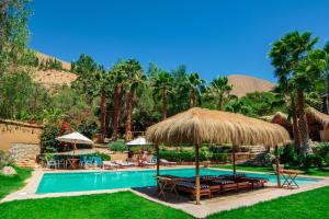 a resort with a swimming pool with chairs and umbrellas at Hotel Misterios del Elqui in Pisco Elqui