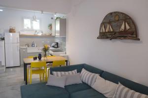 a living room with a blue couch and a kitchen at Moschoula Studios in Parikia