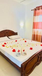 a bed with red flowers on top of it at Beach Star Villa Beruwala in Beruwala +90 photos