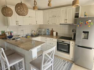 a kitchen with white cabinets and a white refrigerator at VanjAna in Đenovići