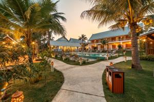 a resort with a swimming pool and palm trees at The Jam Boutique Hotel in Luang Prabang