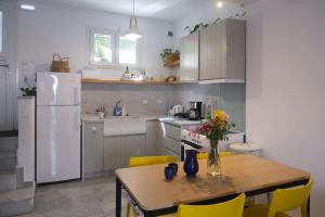 a kitchen with a table and a white refrigerator at Moschoula Studios in Parikia +57 photos