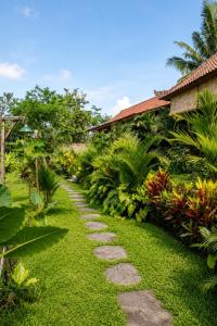 a path through a garden in front of a house at Papahan Bali in Sidemen