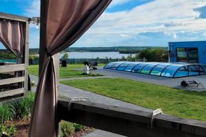 a window with a view of a building and a lake at Comfortable holiday home, pool, sauna, jacuzzi in Brzuze