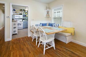 a dining room with a table and chairs and a kitchen at Charming Beach Bungalow in Seal Beach