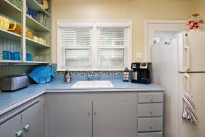a kitchen with a sink and a refrigerator at Charming Beach Bungalow in Seal Beach