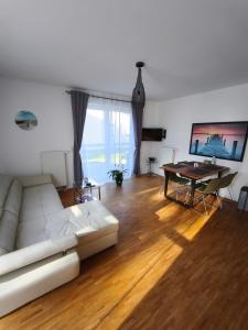 a living room with a white couch and a table at Ferienwohnung Strandparadies 7 in Juliusruh
