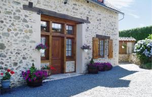 a stone building with a wooden door and flowers at Ancienne Forge Avec Piscine in Saint-Mesmin