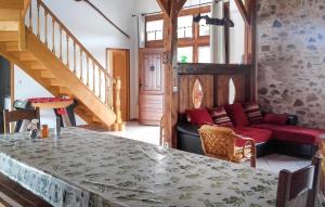 a living room with a table and a red couch at Ancienne Forge Avec Piscine in Saint-Mesmin
