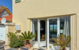 a house with sliding glass doors on the side of it at Maison Vue Mer in Quiberville