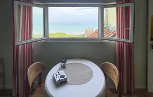 a table and chairs in a room with a window at Maison Vue Mer in Quiberville